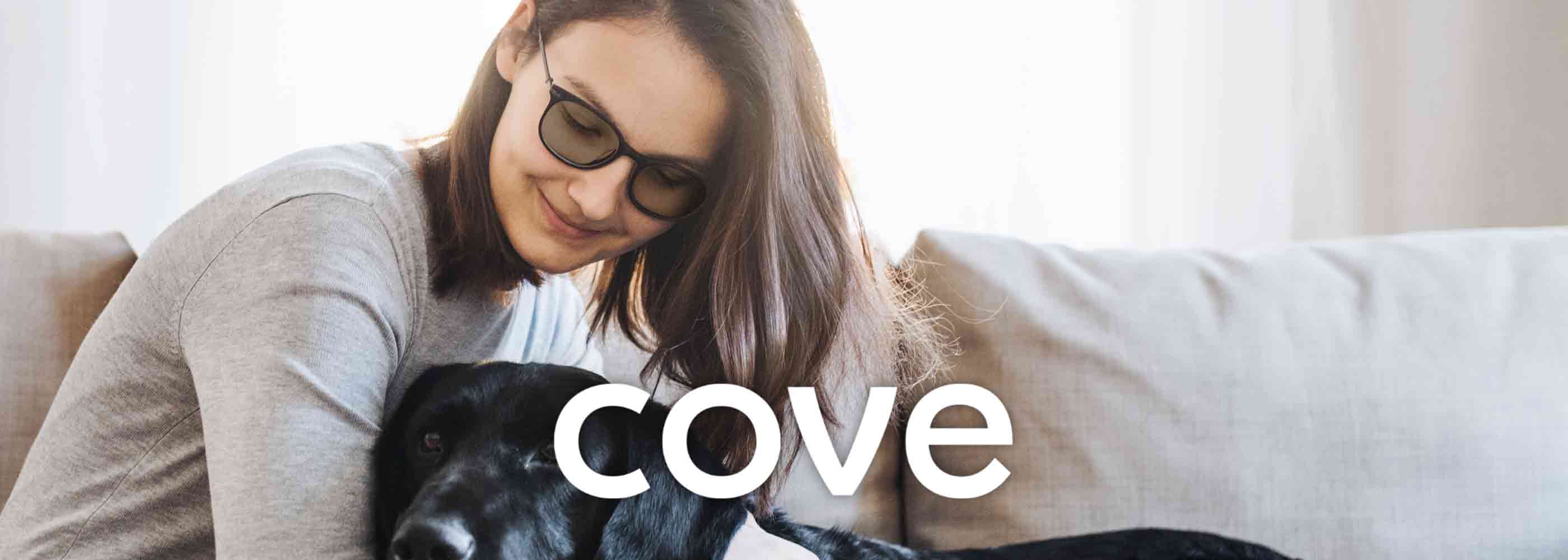 Woman wearing migraine glasses with dog cove banner